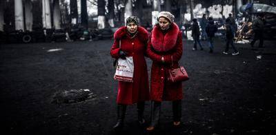 Ukrainian ladies in red outside the damaged Dinamo Kyiv stadium. Photo: AFP Photo/Bulent Klic