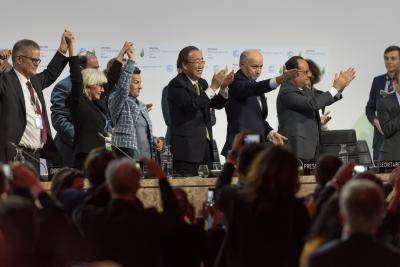 Ministers celebrate the adoption of a historic global warming pact at the COP21 Climate Conference in Paris. Photo via Getty Images.
