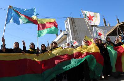 Kurdish women hold flags and banners of the PYD during a demonstration against the exclusion of Syrian Kurds from the Geneva talks on 4 February 2016. Photo by Getty Images.
