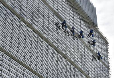 Workers clean the windows of the World Bank headquarters ahead of the 2016 spring meetings of the IMF and World Bank on 10 April 2016 in Washington DC. Photo: Getty Images.
