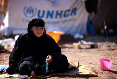 A displaced Iraqi woman, who fled her home due to attacks by ISIS, sits holding prayer beads at the Harsham refugee camp in the autonomous Kurdistan region of Iraq on 22 October 2014. Photo by Getty Images.