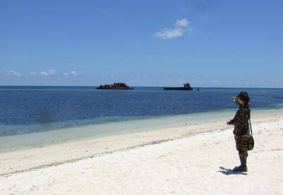 A member of the Philippines military stands on the beach at Thitu island, one of the disputed Spratly Islands. Photo by Getty Images.