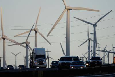 Diesel trucks and cars pass windmills near Banning, California. Photo: Getty Images.