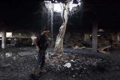 A Yemeni inspects the rubble of a destroyed funeral hall building. Photo by Getty Images.