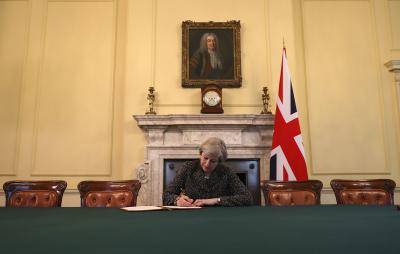 Theresa May signs the official letter invoking Article 50 in London. Photo by Getty Images.