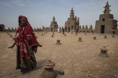 A woman walks on the roof of the Great Mosque of Djenné, a World Heritage Site, after praying. Photo: United Nations.