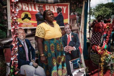Posing for a photo between posters of Kenya President Uhuru Kenyatta and Vice-President William Ruto at a temporary installed photo studio in Nairobi. Photo by Yasuyoshi Chiba/AFP/Getty Images.