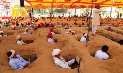 Hundreds of farmers sit in pits as a protest against government plans for land acquisition in October 2017. Photo By Vishal Bhatnagar/NurPhoto via Getty Images.