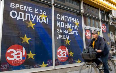 A man passes campaign posters reading 'For a European Macedonia' in Skopje on 29 September 29. Photo: Getty Images.