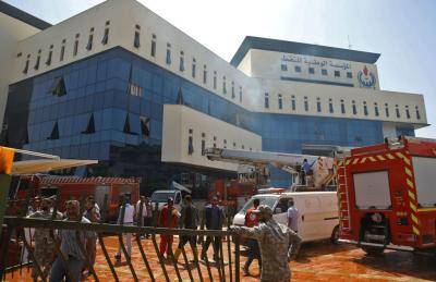 Firefighters and rescuers respond after armed men stormed the headquarters of Libya's National Oil Company in Tripoli on 10 September. Photo: Getty Images.