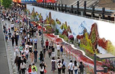 People walk past the 'Belt and Road' ecological wall in Beijing during the Belt and Road Forum for International Cooperation in May. Photo: Getty Images.
