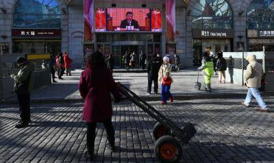 People watch Xi Jinping's opening speech at a gathering to celebrate the 40th anniversary of reform and opening up. Photo: Getty Images.