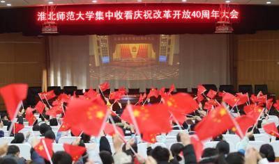 Students holding Chinese national flags watch the live broadcast of the 40th anniversary celebration of China's reform and opening-up at Huaibei Normal University on 18 December. Photo: Getty Images.