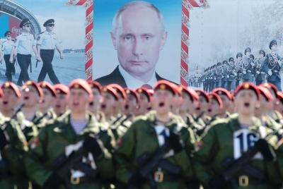 Soldiers drill for the Victory Day parade in front of a portrait of Vladimir Putin. Photo: Getty Images.