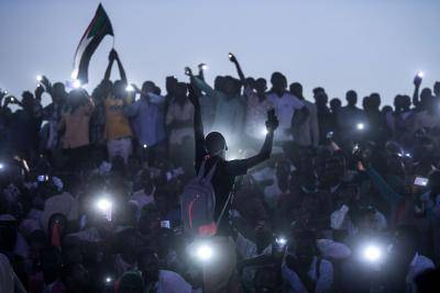 Sudanese protesters open their smartphones lights as they gather for a million-strong march outside the army headquarters in Khartoum on April 25, 2019. Photo by OZAN KOSE/AFP/Getty Images.