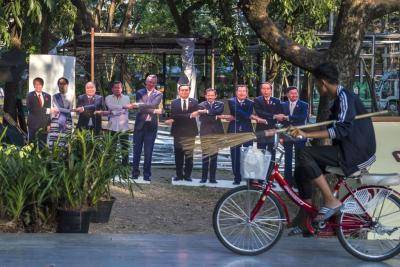 Thailand worker cycles past life-size portraits of the ten leaders of the Association of Southeast Asian Nations (ASEAN). Photo by ROMEO GACAD/AFP/Getty Images.