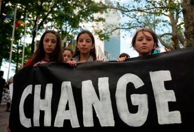 School children hold a placard reading "CHANGE" during the Youth Climate Strike May 24, 2019 outside United Nations headquarters in New York City. Photo by Johannes EISELE/AFP/Getty Images.