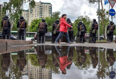 A woman walks past riot police a day after Kazakhstan's presidential elections. Photo: Getty Images.