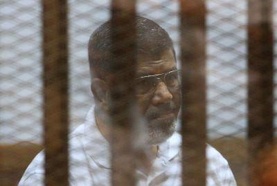 Morsi in the defendant's cage at the police academy in Cairo in 2014. Photo: Getty Images.