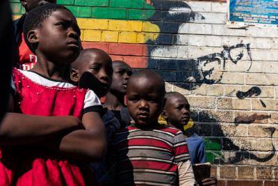 Children stand beside a mural of former Zimbabwe president Robert Mugabe in Harare. Photo: Getty Images.