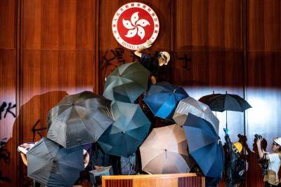 A protester defaces the Hong Kong emblem after protesters broke into the government headquarters in Hong Kong on 1 July, the 22nd anniversary of the city's handover from Britain to China. Photo: Getty Images.