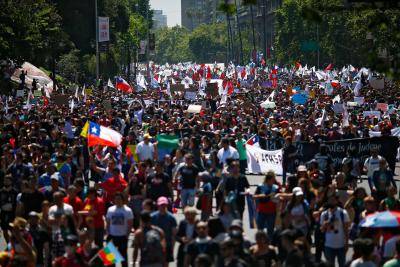Demonstrators march in Santiago, Chile during street protests which erupted over a now suspended hike in metro ticket prices. Photo: Getty Images.