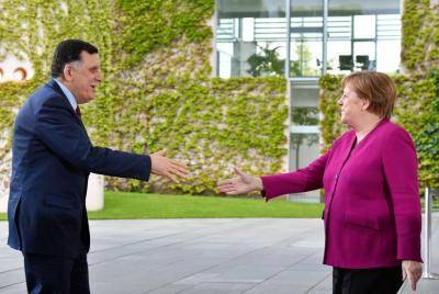 Angela Merkel greets Fayez al-Serraj, prime minister of the Government of National Accord of Libya, in May. Photo: Getty Images.