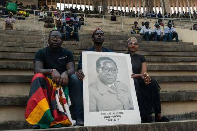 A man holds a portrait of Robert Mugabe during his official funeral ceremony. Photo: Getty Images.