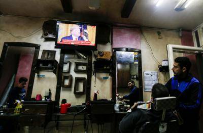 Palestinians watch the televised press conference of Donald Trump and Benjamin Netanyahu on 28 January 2020 at a barber shop in Gaza City. Photo: Getty Images.