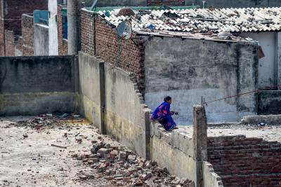 A woman sits on the terrace of a damaged building following clashes between people supporting and opposing the amendment to India's citizenship law, in New Delhi on 27 February. Photo: Getty Images.
