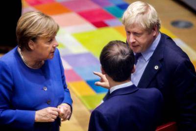 British Prime Minister Boris Johnson (R), French President Emmanuel Macron (C) and German Chancellor Angela Merkel (L) speak upon their arrival for a round table meeting as part of an EU summit in Brussels on 17 October 2019. Photo by Olivier Matthys/Pool/AFP via Getty Images.