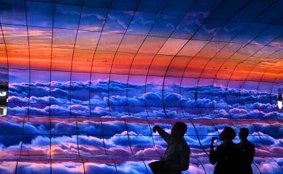 Attendees photograph the Massive Curve of Nature display of 250 curved screens at the Consumer Electronics Show in Las Vegas, USA. Photo by ROBYN BECK/AFP via Getty Images.