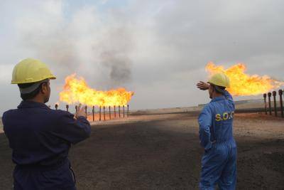 Iraqi Southern Oil Company engineers look towards the flares in the Zubair oil field in southern Iraq. Photo by ESSAM -AL-SUDANI/AFP via Getty Images.