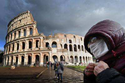 A man with a protective mask by the Coliseum in Rome during the height of Italy's COVID-19 epidemic. Photo by ALBERTO PIZZOLI/AFP via Getty Images.