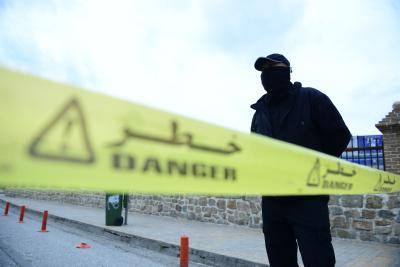 A member of Iraqi security forces stands guard behind a yellow line after the government declared curfew due to coronavirus. Photo by Fariq Faraj Mahmood/Anadolu Agency via Getty Images.
