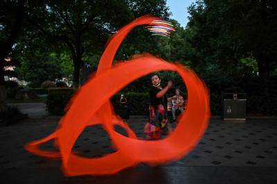 Performing a ribbon dance in Hankou Park, Wuhan on the same day as China warns its huge economy will suffer an immense hit from coronavirus. Photo by HECTOR RETAMAL/AFP via Getty Images.