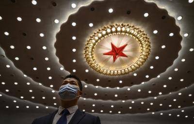 A Chinese security officer wears a protective mask at the end of the closing session of the National People's Congress at the Great Hall of the People. Photo by Kevin Frayer/Getty Images.