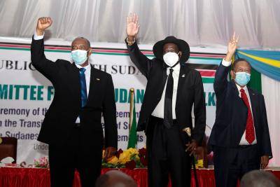 Chairman of Sudan’s Sovereign Council, Lt General Abdel Fattah al Burhan (left), South Sudan President Salva Kiir (centre) and the Sudanese Prime Minister Dr Abdalla Hamdok (right) greet people gathering during the initialling of the Sudan peace deal with the rebel groups in Juba, South Sudan. Photo by AKUOT CHOL/AFP via Getty Images.