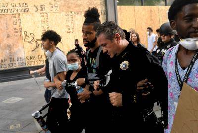 Denver police chief Paul Pazen marches arm and arm with peaceful protesters during a protest over the death of George Floyd. Photo by RJ Sangosti/MediaNews Group/The Denver Post via Getty Images.
