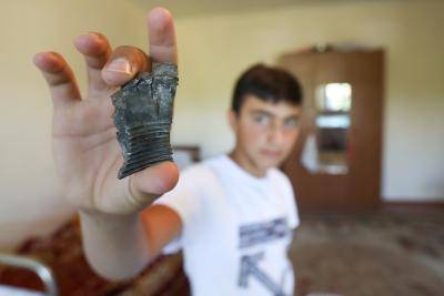 A man shows a piece of shrapnel after attacks carried out by the Armenian army at Dondar Kuscu village near Tovuz, Azerbaijan. Photo by Aziz Karimov/Getty Images.