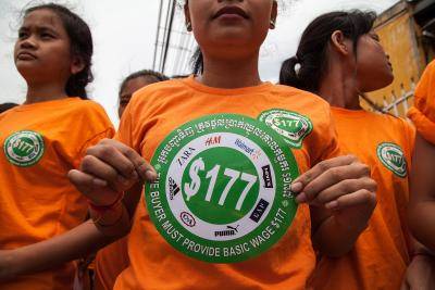 Garment workers hold stickers bearing US$177 during a demonstration to demand an increase of their minimum salary in Phnom Penh, Cambodia. Photo by Omar Havana/Getty Images.