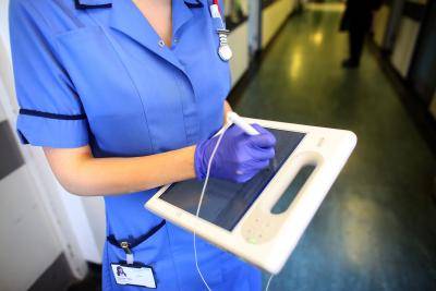 Nurse uses a wireless electronic tablet to order medicines from the pharmacy at The Queen Elizabeth Hospital, Birmingham, England. Photo by Christopher Furlong/Getty Images.