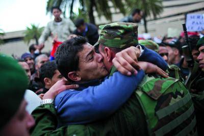 A protestor hugs a soldier during a demonstration in front of </body></html>