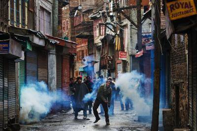 A Kashmiri muslim throws back a can of tear gas shot by Indian police on February 05, 2010 in Srinagar, Kashmir, India. 